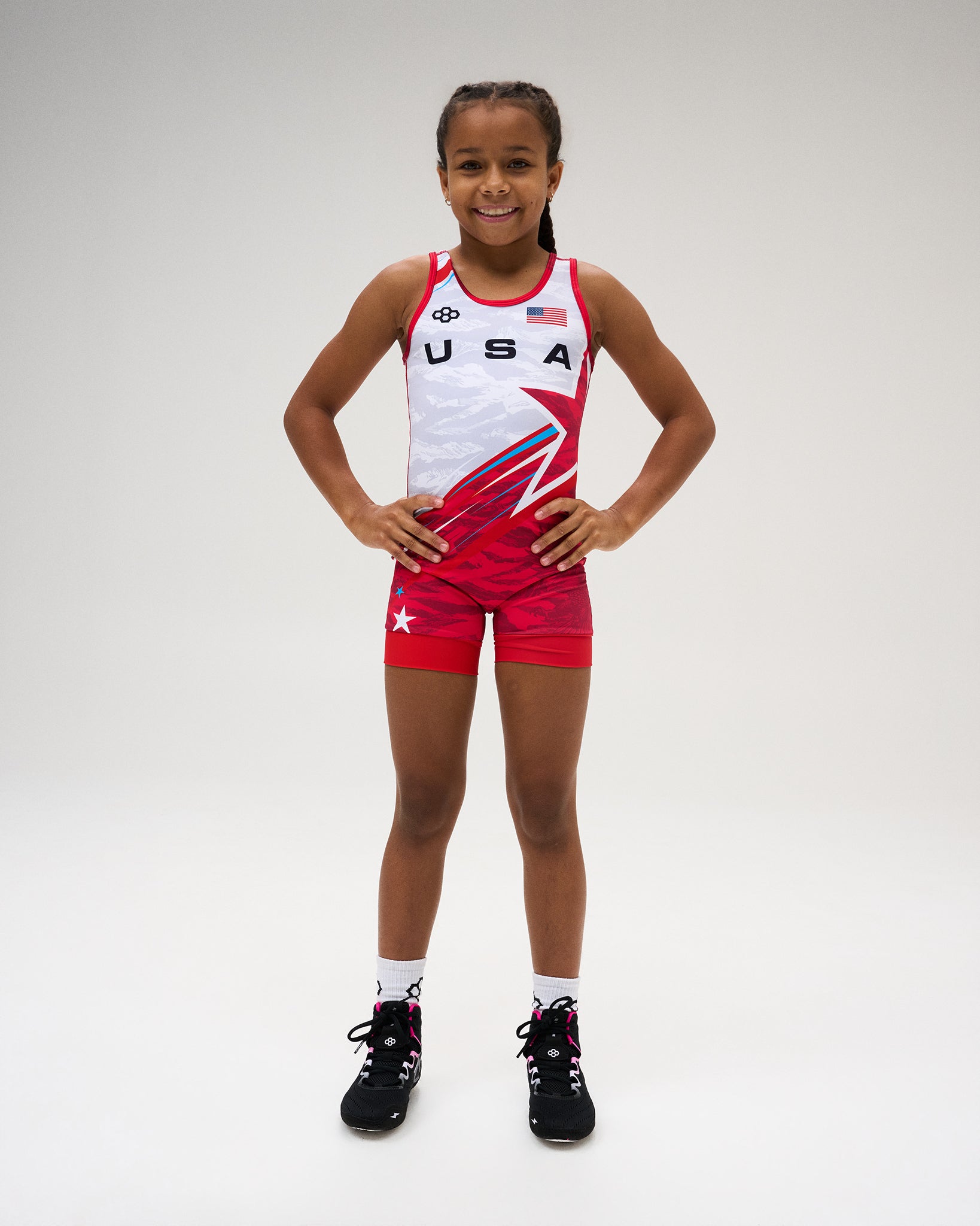 USA Wrestling Shooting Star Girls’ Elite 2.0 Singlet in red and white, featuring USA chest graphics, American flag detail, RUDIS branding, and bold patriotic styling.