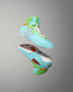 RUDIS Scooby-Doo Colt 4.0 youth wrestling shoes shown in angled side and outsole views, featuring turquoise and green uppers, white soles, and orange floral details.