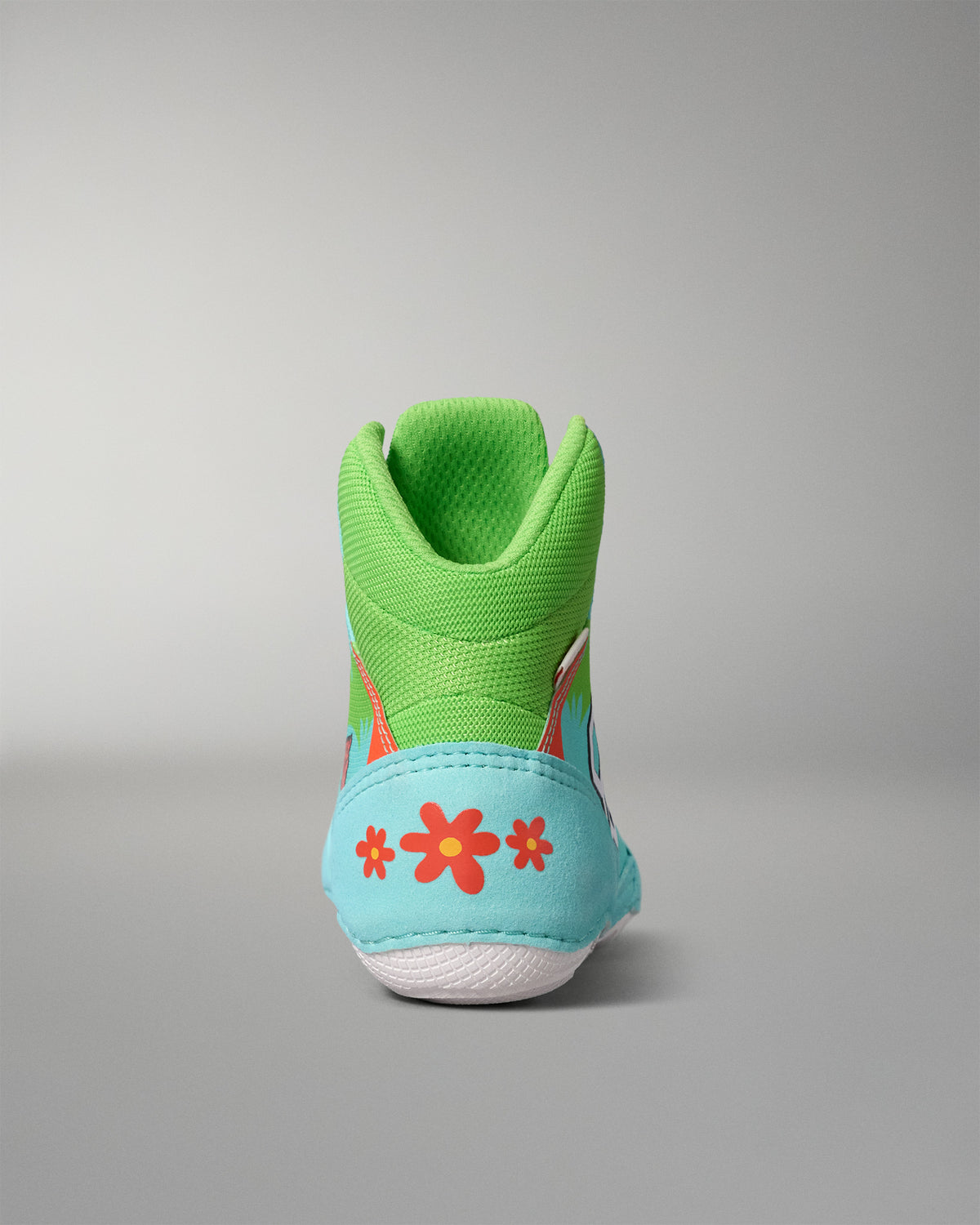 Rear view of the RUDIS Scooby-Doo Colt 4.0 youth wrestling shoe featuring a green padded ankle collar, turquoise heel panel, orange flowers, and white outsole.