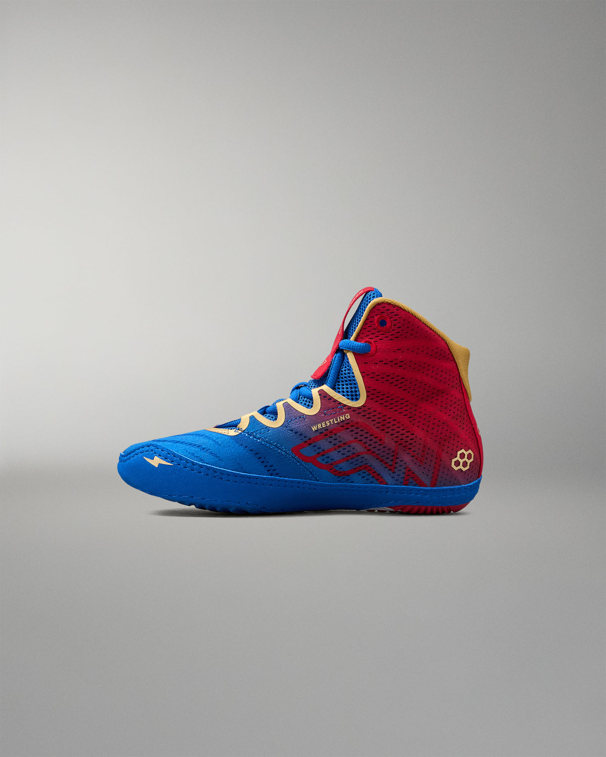 Inner side view of RUDIS Wonder Woman Hildebrandt 2.0 girls' wrestling shoe featuring red and blue panels, Wonder Woman-inspired graphics and gold accents.