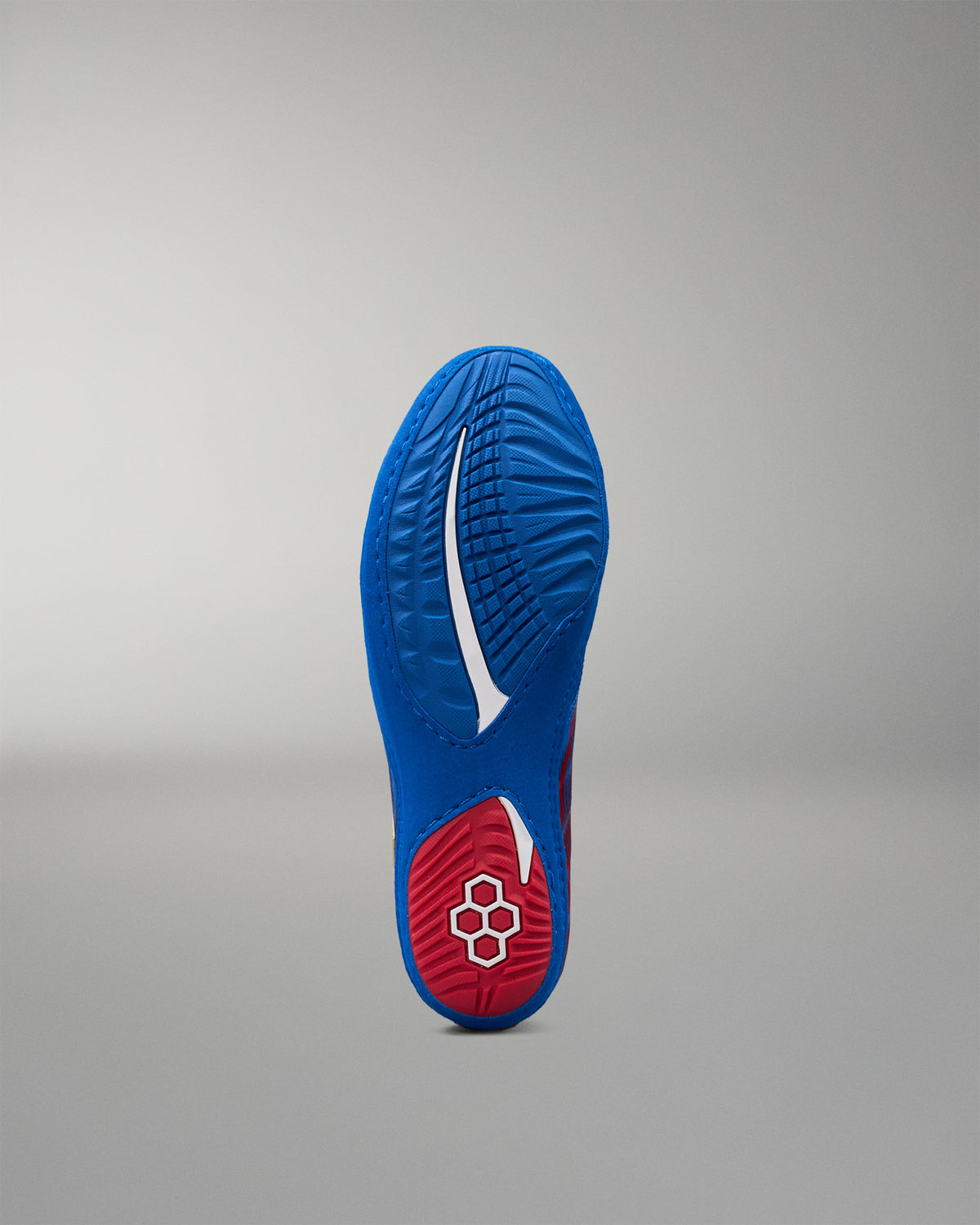 Bottom view of RUDIS Wonder Woman Hildebrandt 2.0 girls' wrestling shoe showing the textured blue outsole, red heel traction area and RUDIS emblem.