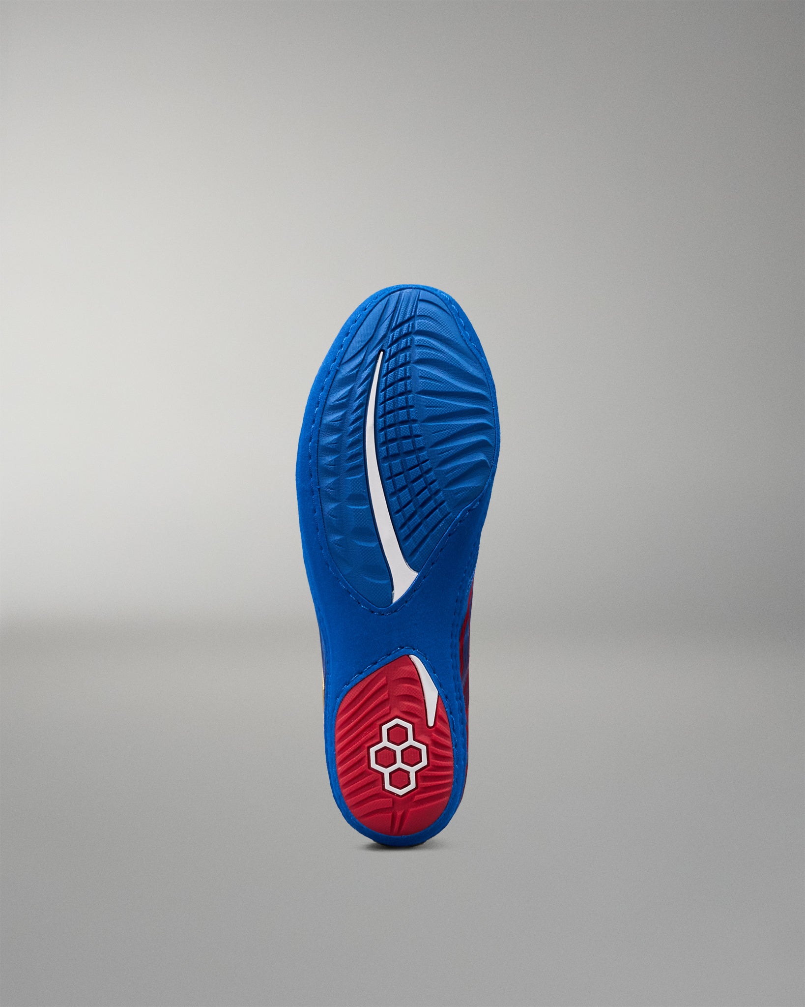 Bottom view of RUDIS Wonder Woman Hildebrandt 2.0 girls' wrestling shoe showing the textured blue outsole, red heel traction area and RUDIS emblem.