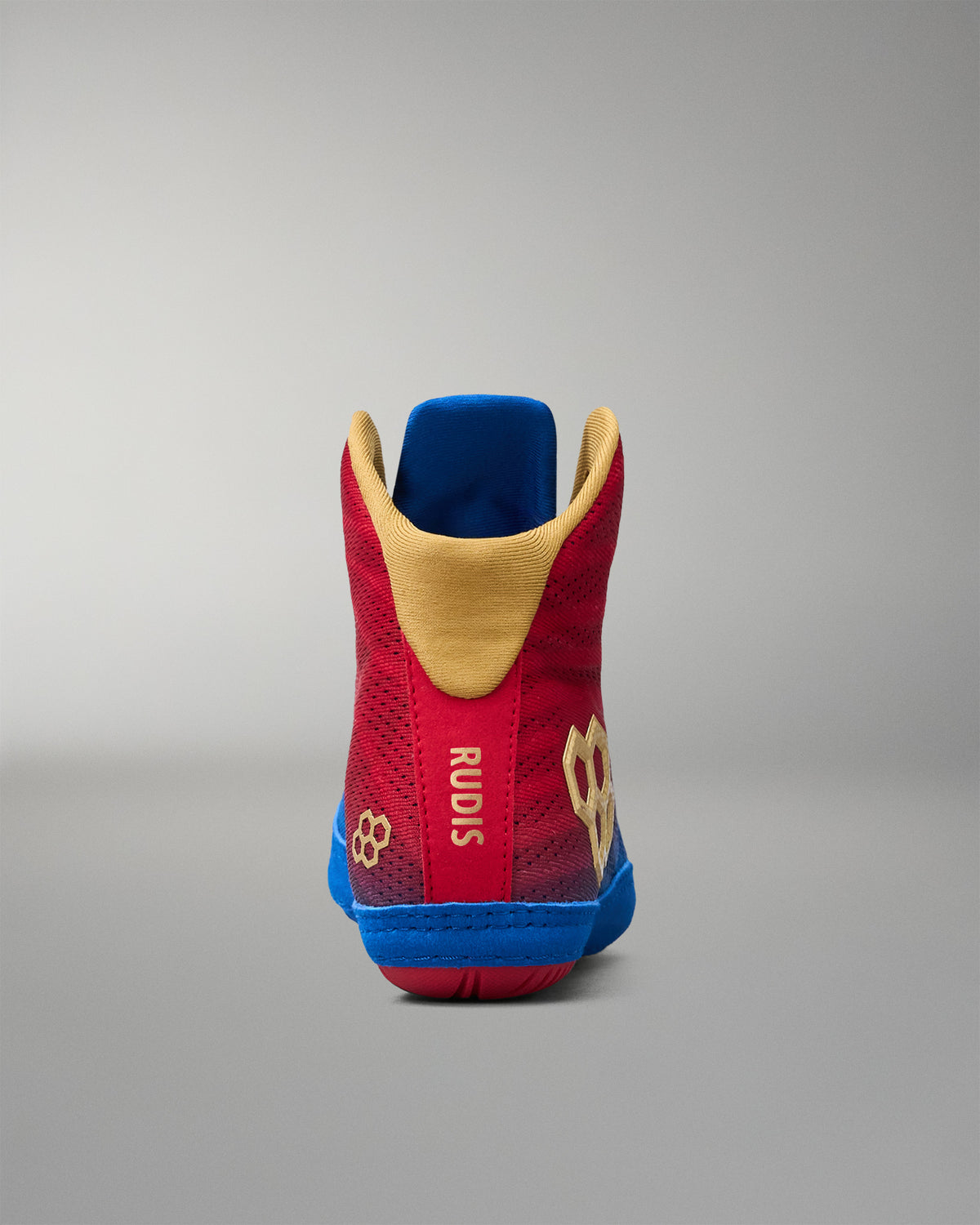 Rear view of RUDIS Wonder Woman Hildebrandt 2.0 girls' wrestling shoe, highlighting the red heel, gold collar lining, gold RUDIS emblem and blue sole.
