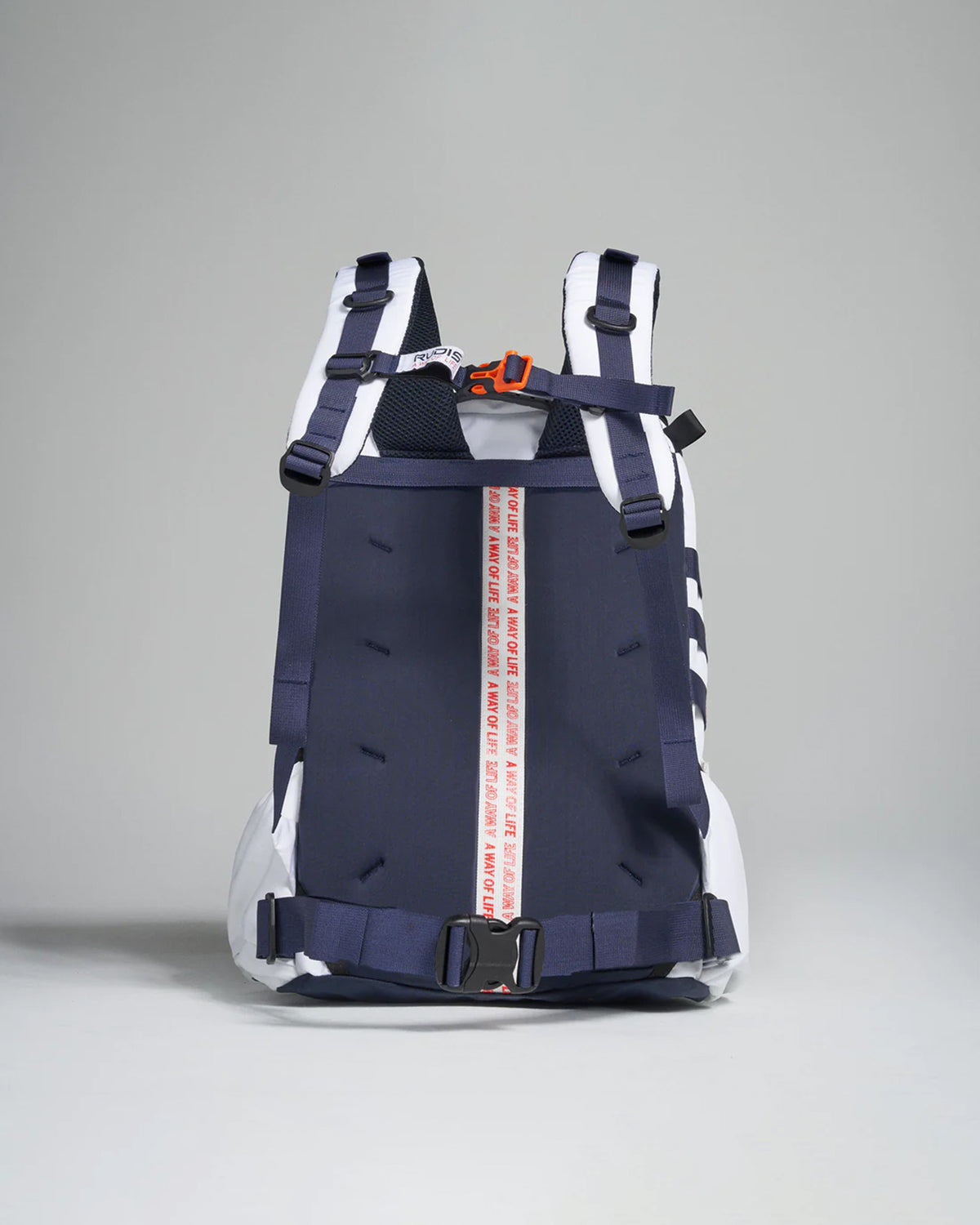 A modern navy blue and white backpack with adjustable straps a bold red and white branded strap in the center and a streamlined design suitable for both lifestyle and functional use