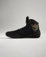 A stylish black wrestling shoe featuring a high-top design accented with a gold logo and branding for enhanced athletic performance