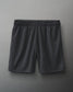 Dark gray athletic shorts with an elastic waistband and a small logo, made from lightweight mesh fabric suitable for sports.
